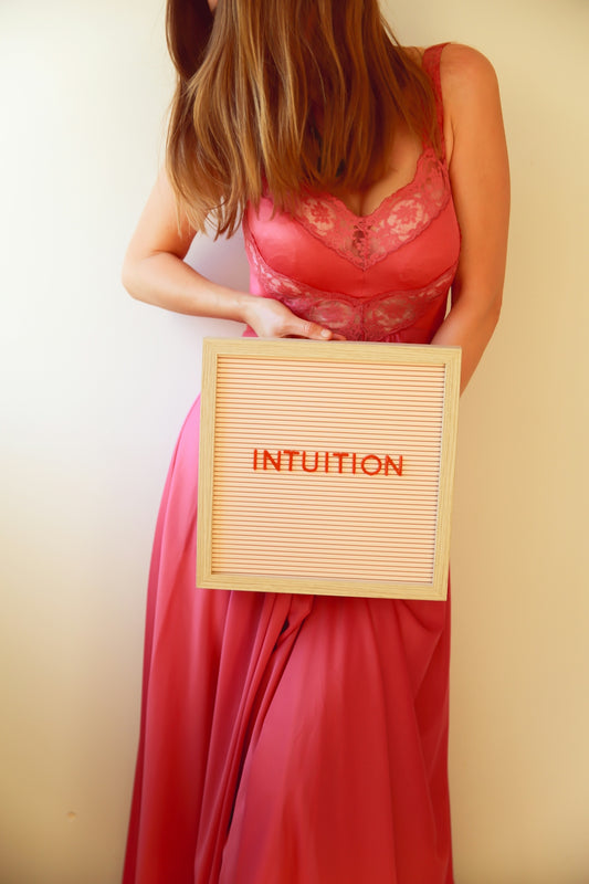 A woman holds a sign that reads intuition.
